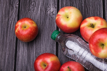 Fresh apples around bottle