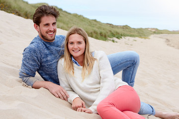 Portrait Of Couple Sitting On Beach Together