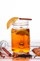 Hot spiced tea in jar on wooden table