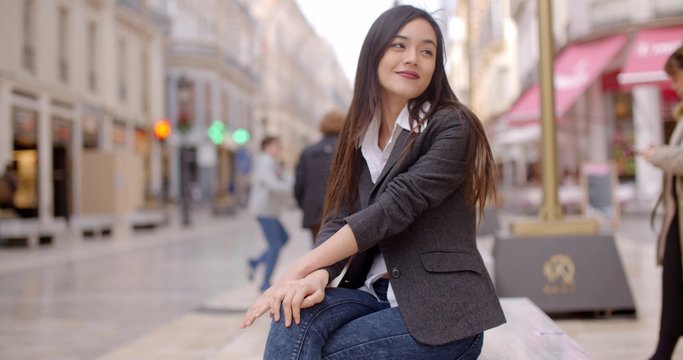 Relaxed attractive young woman sitting on a bench in town waiting for someone  close up view with copy space