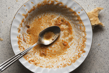 close up of a dirty plate after a finished meal stained with food leftovers