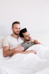 Asleep gay couple lying in bed