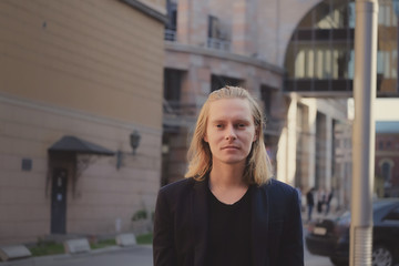 Long haired young man outdoor in the city