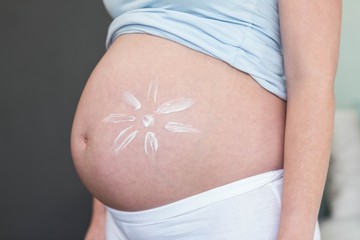 Pregnant woman with cream on her belly