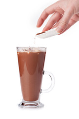 Female hand sprinkle with grated chocolate hot drink with marshm
