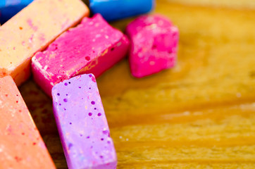 Bright pieces of chalk on wooden background