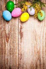 Fototapeta na wymiar Easter eggs with bunch mimosa copyspace