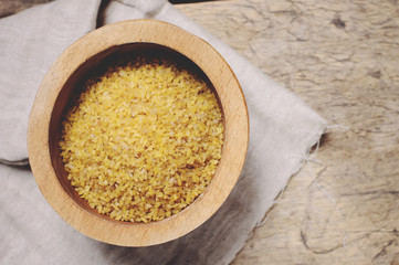 Raw Bulgur on wooden background