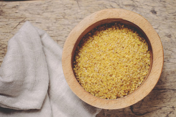 Raw Bulgur on wooden background
