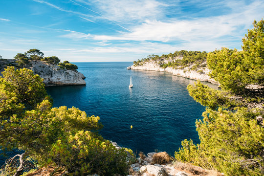 Fototapeta Boat leaves from bay to open sea in Calanques on the azure coast
