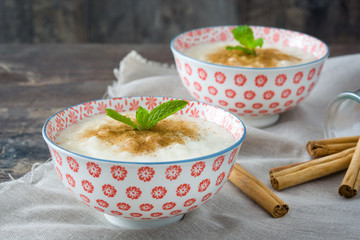 Rice pudding with cinnamon on wood
