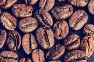 Coffee beans on a black background. Raw coffee beans. Grained product. Hot drink. Close up.