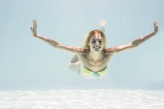 Fit woman swimming under water