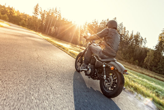 Man seat on the motorcycle on the forest road.