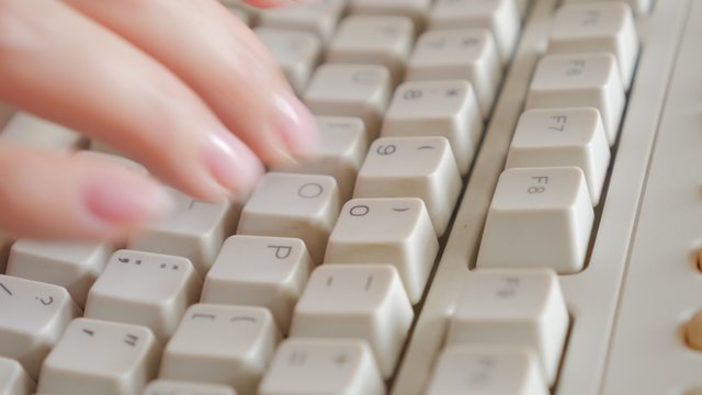 Business woman typing on old style keyboard keys close-up slow tilting 4K 2160p UltraHD footage - Female fingers over retro beige keyboard keys typing 4K