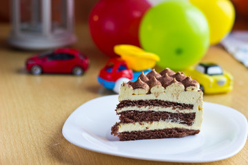 Baby boy first birthday party. Focus on cake with blurred multicolored background