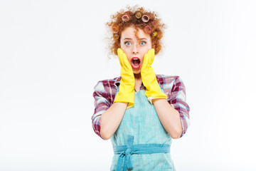 Amazed redhead woman with cleaning gloves