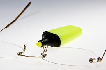 Marker liegt auf einer weissen Unterlage mit einer Lesebrille