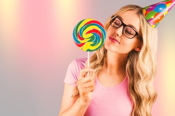 Composite image of a beautiful hipster holding a giant lollipop  - Powered by Adobe