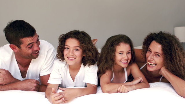 Cute family laughing on their bed