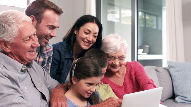Cute multi generation family using laptop on the couch