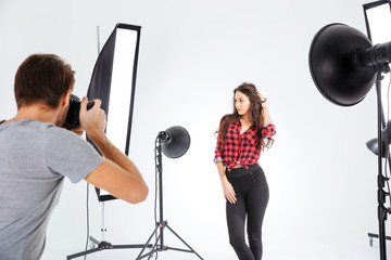 Photographer shooting model in studio