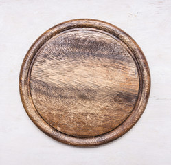 round, vintage wooden cutting board with text area on wooden rustic background top view close up