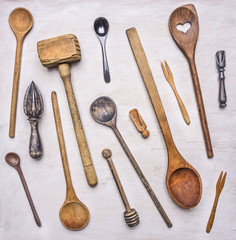 Flat lay variety of wooden cutlery, spoons, forks, meat beater on wooden rustic background top view close up