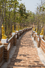 golden asian angel statue beside the walkway