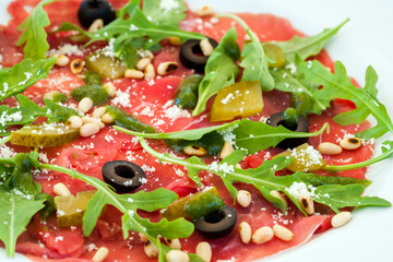 Beef carpaccio with rocket and olive dressing.