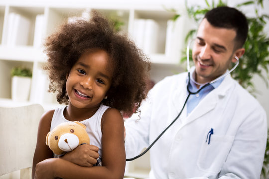 Beautiful smiling afro-american girl with her pediatrician