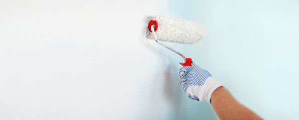 close up of male in gloves painting wall