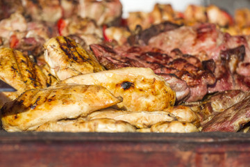 Different kind on grilled meat and sausages with smoke and steam from the grill