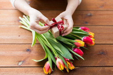 close up of woman with gift box and tulip flowers