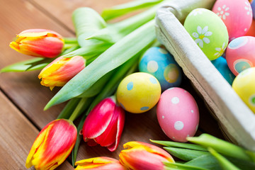 Obraz na płótnie Canvas close up of colored easter eggs and flowers