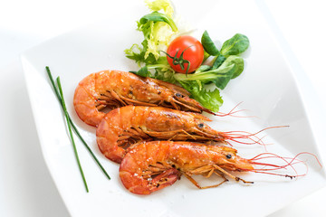 Top view of fresh grilled jumbo prawns with green salad.