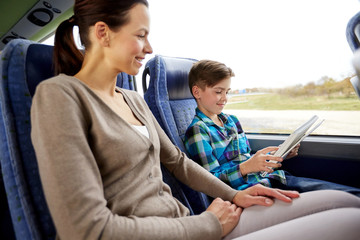 happy family with tablet pc sitting in travel bus