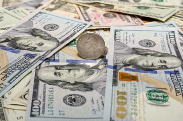 Fototapeta premium Quarter dollar coin and One Hundred Dollar banknotes currency of the United States