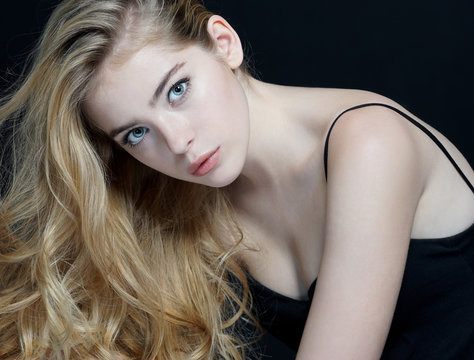 Woman with beauty face, skin care concept. Close-up of an attractive girl of European appearance on dark background.