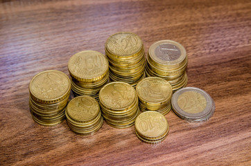 different  golden euro coins on wooden table background
