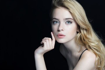 Beautiful young lady with make up face. Close-up of an attractive girl of European appearance on dark background.