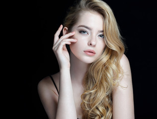 Beautiful sensual blonde girl. Close-up of an attractive girl of European appearance on dark...