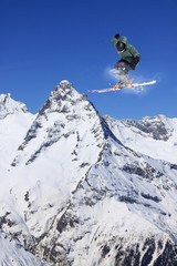 Flying skier on mountains. Extreme sport.