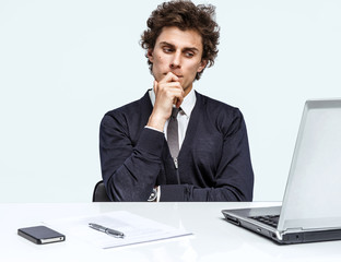 Doubter Businessman sitting in his office as he reads information or looks at a presentation on his...