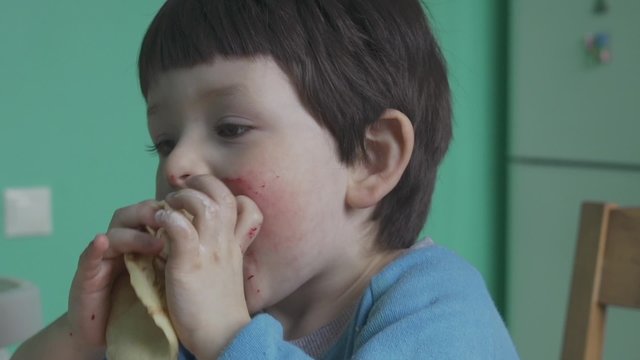 Little boy eating tasty pancakes