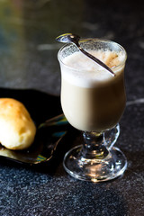 cup of coffee and a bun on a black plate. still life