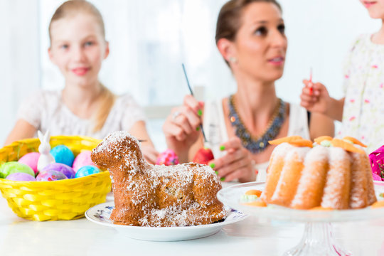 Familie f&auml;rbt Eier zu Ostern und backt Osterlamm