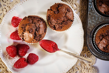 Chocolate muffins with red juicy raspberries