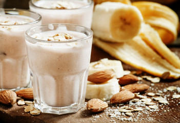 Banana smoothie with milk, oatmeal and almonds on the old wooden