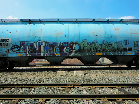 Blue industrial train car with tracks - landscape color photo